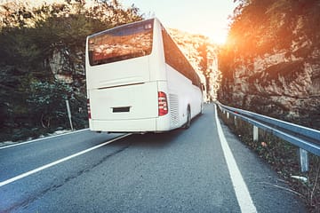 Bus sur route goudronnée dans une belle journée de printemps à la campagne