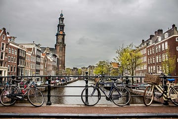 Beau cliché de vélos appuyé à nouveau la clôture sur un pont au-dessus de la rivière